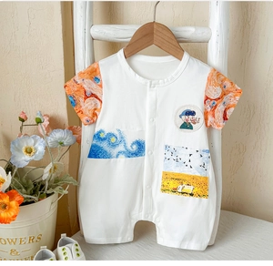 Detailed view of white baby romper featuring Starry Night and sunflower art patterns