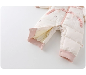 Detail of baby winter romper with delicate floral embroidery and soft quilted fabric