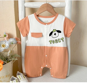 Détail d'un barboteuse bébé à manches courtes avec col orange à boutons et motif chien