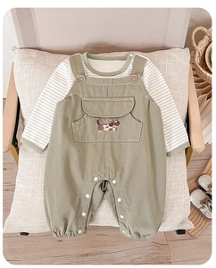 Close-up of olive green cotton baby overalls with embroidered puppy and snap buttons