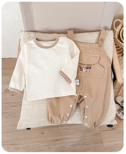 Detail of baby cotton striped shirt and khaki overalls with cute puppy embroidery