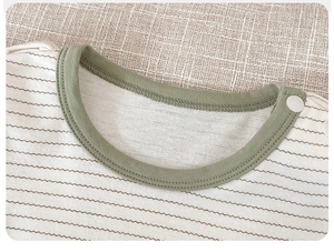 Detail of baby striped cotton top with green ribbed neckline and shoulder snap button