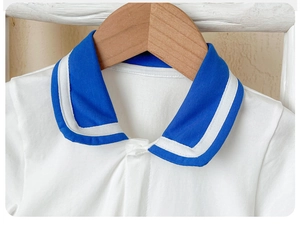 Close-up of baby romper with blue sailor collar and white stripes on cotton fabric
