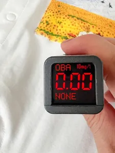 Infant cotton bodysuit tested for zero fluorescent agents with a handheld digital meter