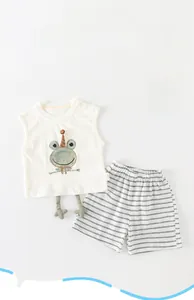 Close-up of baby summer set with cartoon frog tank top and striped shorts on white background