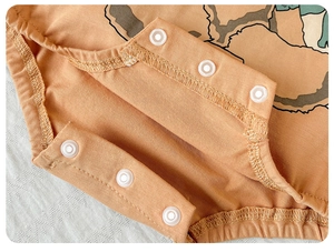 Détail de l'entrejambe d'un body bébé en coton avec six boutons-pression en résine