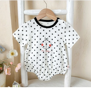 Detail of baby cotton bodysuit featuring black polka dots and a cute rabbit illustration