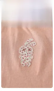 Détail du haut rose pour bébé avec broderie lapin à fleurs et coutures de haute qualité
