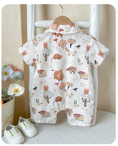 Detail of baby short sleeve cotton romper featuring cute forest animals and floral prints