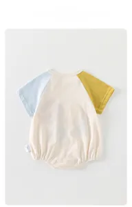 Detail of short sleeve baby bodysuit featuring contrast raglan sleeves and soft cotton knit