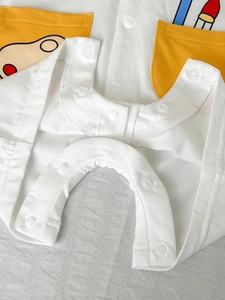 Short sleeve baby romper in soft white cotton with yellow cartoon pocket and snap buttons