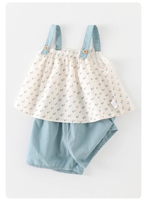 Dettaglio flat lay di top floreale e pantaloncini blu per bambini in cotone morbido