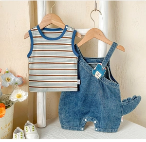 Détail de la salopette en jean dinosaure pour bébé avec gilet rayé et queue en relief