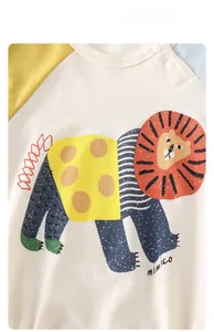 Close-up of baby cotton bodysuit with cartoon lion print and contrast raglan sleeves