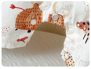 Close-up of baby romper crotch featuring snap button closure and mushroom print fabric