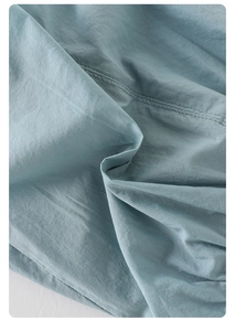 Vista macro del tessuto a trama blu-grigio con dettagli di cuciture a doppio ago