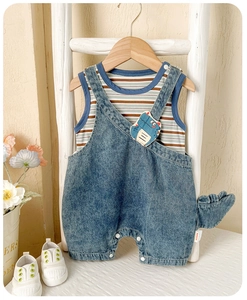 Détail de la salopette en jean dinosaure avec queue 3D et gilet en coton rayé