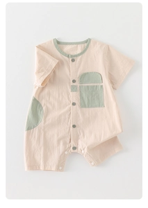 Detail of short sleeve cotton baby romper with buttons and contrast pocket design