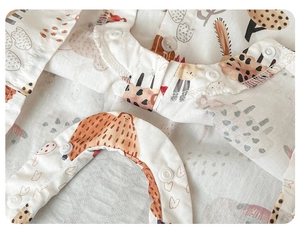 Close-up of cotton baby romper with giraffe print and durable resin snap buttons