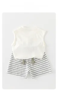 Detailed flat lay of toddler summer set featuring a white vest and striped shorts with 3D fins