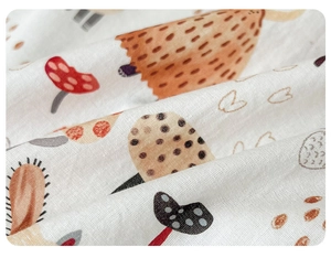 Close-up of soft floral cotton fabric for baby rompers featuring cute mushroom prints