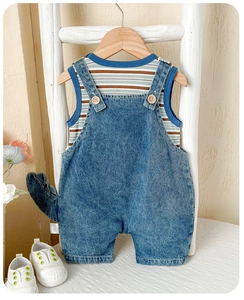 Détail d'une salopette en jean pour bébé avec queue de dinosaure 3D et débardeur
