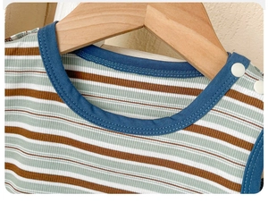 Détail du t-shirt rayé pour bébé avec boutons-pression et bordure d'encolure