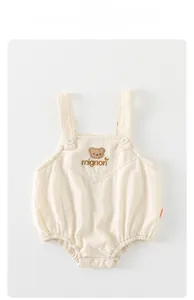 Detail eines Baby-Stramplers mit süßer Bärenstickerei und weicher Baumwollstruktur