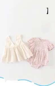 Détail d'un ensemble de bodys d'été pour bébé avec fleurs et bords délicats en dentelle