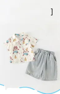 Detail view of toddler boy summer set featuring cartoon bear shirt and denim shorts