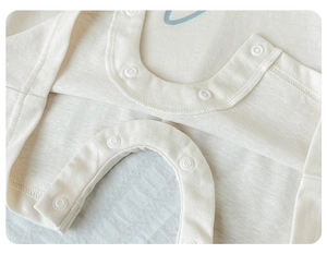 Detailed view of soft cotton baby romper fabric with durable white resin snap buttons