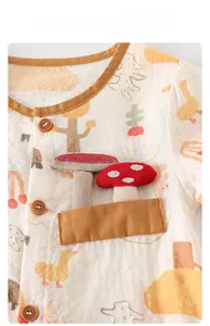 Close-up of baby romper featuring breathable cotton fabric with mushroom patch and wood buttons
