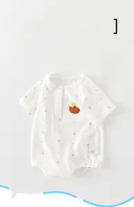 Détail d'un body bébé à manches courtes avec imprimés fraises et écusson canard