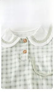 Detail of infant plaid romper featuring Peter Pan collar and cute bear wooden buttons