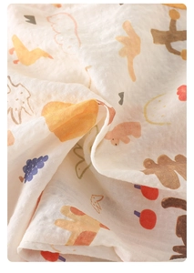 Close-up of baby gauze blanket with cute cartoon patterns and soft bubble texture