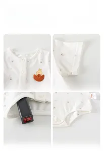 Détail d'un body bébé en coton avec motifs fraises et col à boutons-pression