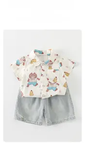 Detailed flat lay of boys casual summer set with cartoon bear shirt and denim shorts