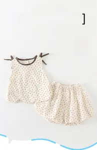 Detailed macro view of sleeveless baby floral set with brown bow patterns on cotton fabric