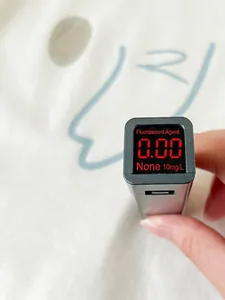 Baby cotton romper shown with a fluorescent agent detector showing zero results