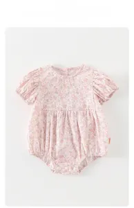 Vue détaillée du barboteuse bébé à fleurs avec manches bouffantes et boutons-pression