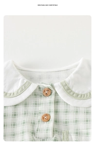 Detail of baby plaid romper showing Peter Pan collar and bear buttons on green fabric