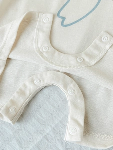 Breathable cotton baby romper in cream with snap buttons and light blue print detail