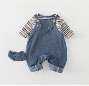 Détail d'une salopette en jean pour bébé avec queue de dinosaure amovible et body rayé