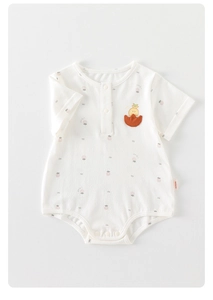 Détail d'un barboteuse bébé à manches courtes avec motif fraise et poche canard
