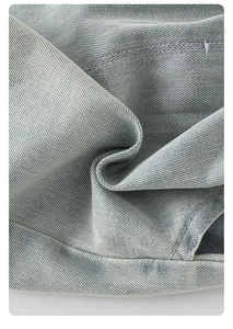 Detailed close-up of light blue denim fabric texture and fine stitching on kids' outfit