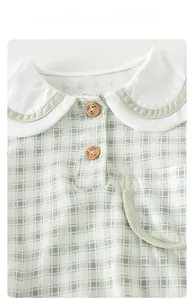 Detail of baby plaid onesie featuring Peter Pan collar and bear-engraved wooden buttons