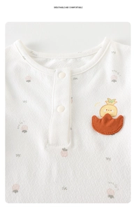 Détail d'un body blanc pour bébé en maille filet avec poche orange et imprimé