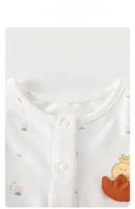 Détail de l'encolure du body bébé avec texture gaufrée et boutons-pression blancs