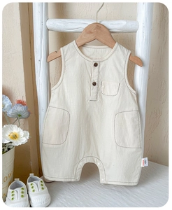 Detail of baby cotton sleeveless romper showing breathable fabric and wooden buttons