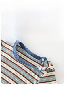 Détail du haut en tricot rayé pour bébé montrant le coton doux et les boutons à l'épaule